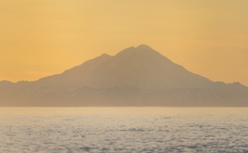 View of Cook Inlet on white mountain peaks of Mount Redoubt at sunset, midnight sun, Aleutian