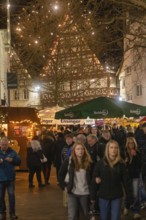 People stroll through a well-visited, festively lit Christmas market, Christmas market 2025,