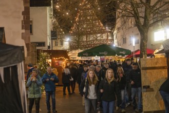 Lively Christmas market with numerous visitors and illuminated half-timbered houses, Christmas