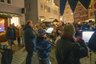 A brass band plays on a busy street surrounded by bright decorations, Christmas market 2025,