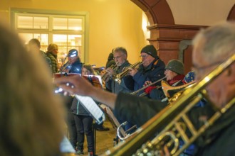 Musicians playing brass instruments indoors with winter clothes, Christmas market 2025, Nagold,