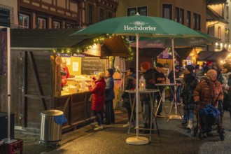 Residents and visitors gather around a food stand with festive lights, Christmas market 2025,