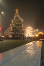 Festively illuminated Christmas market with illuminated tree and Ferris wheel at night, Christmas