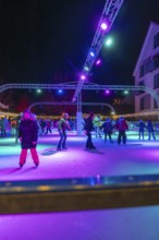 Night view of an ice rink with colorful lights, many people skating, Christmas market 2025, Nagold,
