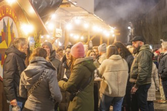 A group of people meet at a busy Christmas market, Christmas market 2025, Nagold, Black Forest,