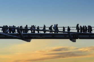 Pedestrians, tourists cross the Millenium Bridge, which connects the City of London in the north to