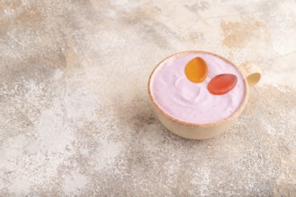 Purple Yogurt, with jelly candy on brown concrete background, side view, copy space, minimalism