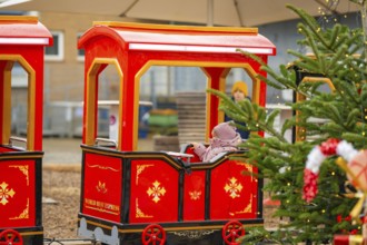 A child on a Christmassy decorated miniature train at a Christmas market, Sindelfingen, Böblingen