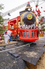 Red toy train with cheerful decoration on rails in a festive setting, Sindelfingen, Böblingen