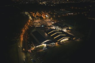 Night view of an illuminated building structure with surrounding parking spaces, Sindelfingen,