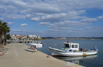Two fishing boats in calm water near a concrete pier under cloudy sky, Alibey, Alibey Adasi Island,