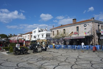 Colourful streetscape with historic buildings and cobblestones, cozy outdoor dining under blue