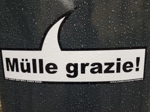 Funny sticker with inscription on a trash can, MÃ¼lle grazie, We give the trash a basket,