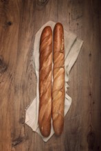 Fresh French baguette, two pieces, top view, on the table, no people