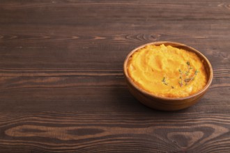 Sweet potato porridge in wooden bowl on wooden background. Diet, healthy eating concept. side view,