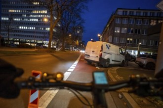 Cycling in the city, in the dark, in the evening, cycling on a bike lane, marked, delivery vehicle