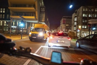 Cycling in the city, in the dark, in the evening, cycling on a bike lane, marked, between 2 lanes,