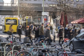 Passers-by on a GrunerstraÃŸe pedestrian crossing near Alexander Platz, bicycle parking lot in