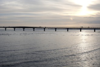 Silhouettes of people on a pier, sunrise, Scharbeutz, 29.11.2025, Scharbeutz, Schleswig-Holstein,