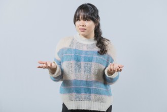 Confused asian woman spreading hands bewildered isolated. Unsure female with face worried