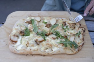 Flammkuchen with goat cheese, pears and nuts served on a wooden board, Ahrenshoop, DarÃŸ,