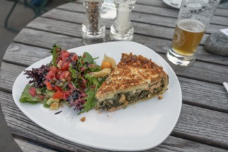 Quiche served with spinach and salad in a garden café, Ahrenshoop, DarÃŸ, Mecklenburg-Vorpommern,