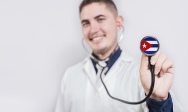 Doctor showing stethoscope with Cuba flag. Cuba national healthcare concept