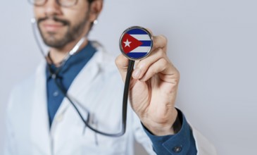 Doctor holding stethoscope with Cuba flag. Cuba health and care concept. Cuba flag on stethoscope