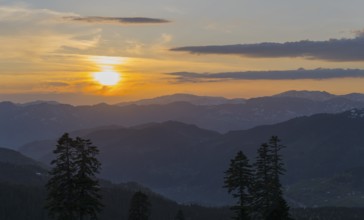 An impressive sunset over a mountainous landscape with a golden sky, view from Goderdzi Pass,