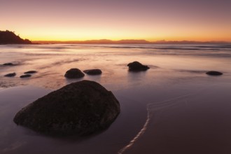Washed stones and rocks on a beach at sunset in Byron Bay, Wategos Beach, New South Wales,