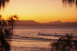 View of the ocean and Wategos Beach on the promenade at sunset. Mt- Warning, Wollumbin in the