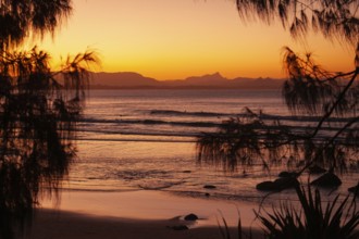 View of the ocean and Wategos Beach on the promenade at sunset. Mt- Warning, Wollumbin in the