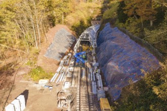 View from above of tunnel construction work with protective tarpaulins and building materials in