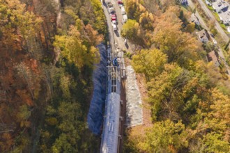 Overview of a tunnel construction site in autumn forest from an oblique bird's eye view, Hermann