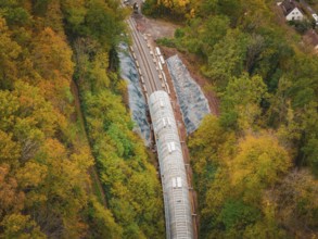 Construction site of a tunnel from above in autumn forest with green and colorful trees, Hermann