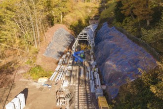 Wide-angle view of a construction site with the construction of metal tunnels along a railroad,