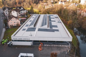 Building with solar systems in a rural environment, near a river, PV at Walther Lindner Sporthalle