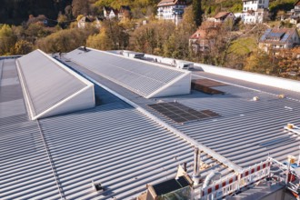 Close-up of a roof with solar panels in the middle of an autumn village landscape, PV at Walther