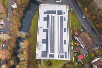 Aerial view of a building with solar panels, surrounded by river and roads, PV at Walther Lindner