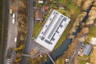 Aerial view of a building with solar panels, surrounded by river and trees, PV at Walther Lindner