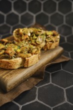 A delicious mushroom sandwich is arranged on a wooden board. The sandwich includes honey mushrooms,