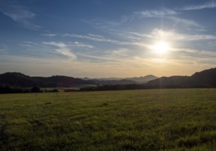 Sun over gentle mountain landscape and meadows, Bohemia, Lusetian Mountains, Czech Republic
