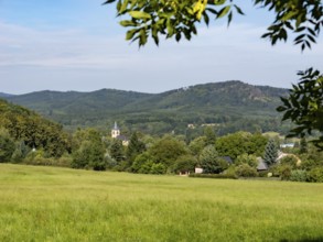 Small village with church in a gentle mountain landscape and meadows, Lusetian Mountains, Bohemia,