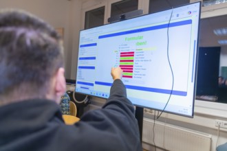 Person interacting with digital content on a large screen, Jugend Forschungszentrum Nagold, Calw