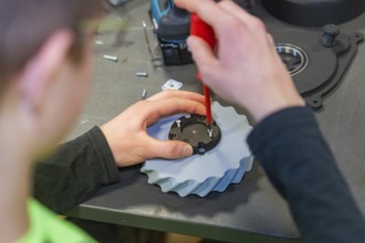 Gear assembly with screwdriver in the workshop, Jugend Forschungszentrum Nagold, Calw district,