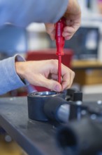 Person uses screwdriver to mount on a technical device, Jugend Forschungszentrum Nagold, Calw