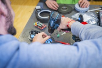 Two people use drills and work on electronic components, Jugend Forschungszentrum Nagold, Calw