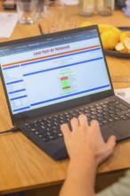 Hand operates a laptop with mathematics software on a wooden table, Jugend Forschungszentrum