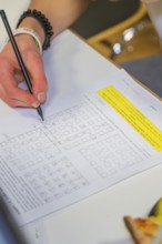 Hand writes math problems on a worksheet, Jugend Forschungszentrum Nagold, Calw district, Germany