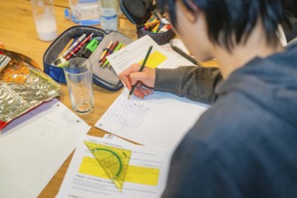 Student draws and solves tasks in a notebook on a table, Jugend Forschungszentrum Nagold, Calw